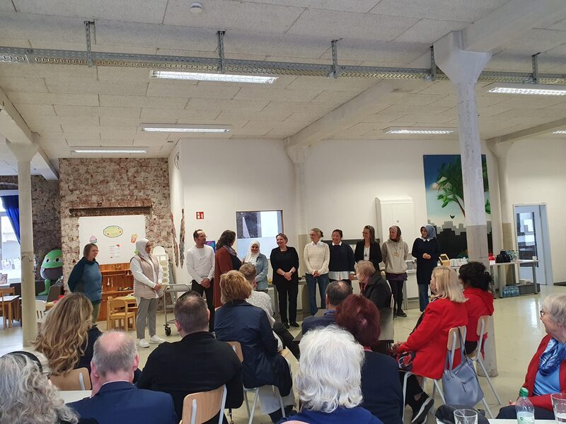 Gruppe von Menschen, stehend und sitzen, im Plenumssaal