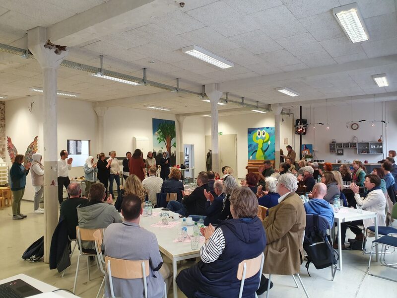 Gruppe von Menschen, stehend und sitzen, im Plenumssaal (Bild 2)