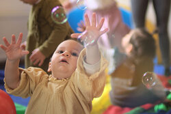 Fotos einer Kleinkinder-Gruppe die mit Seifenblasen spielt