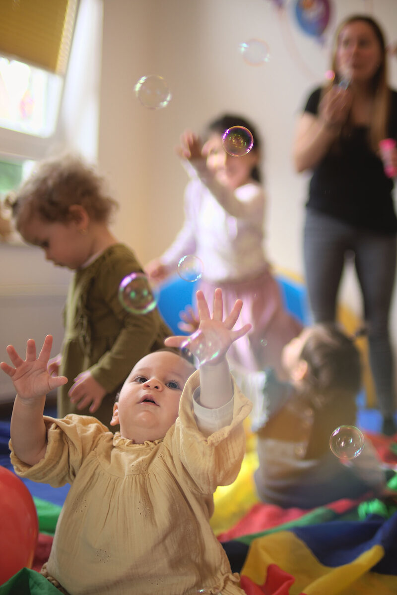 Kinder spielen mit Seifenblasen